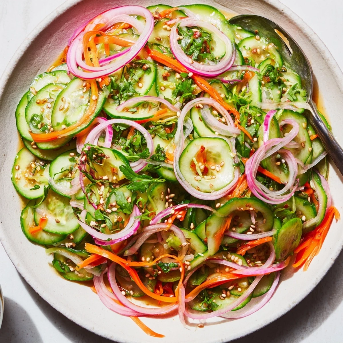 Vibrant cucumber salad remix with tangy dressing and sesame seeds, ideal for summer meals.  