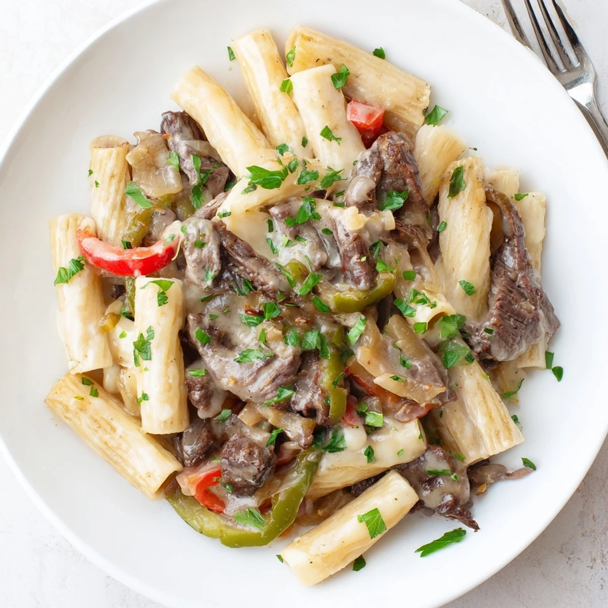 Hearty Philly cheese steak pasta served warm, bursting with flavor and textures.  