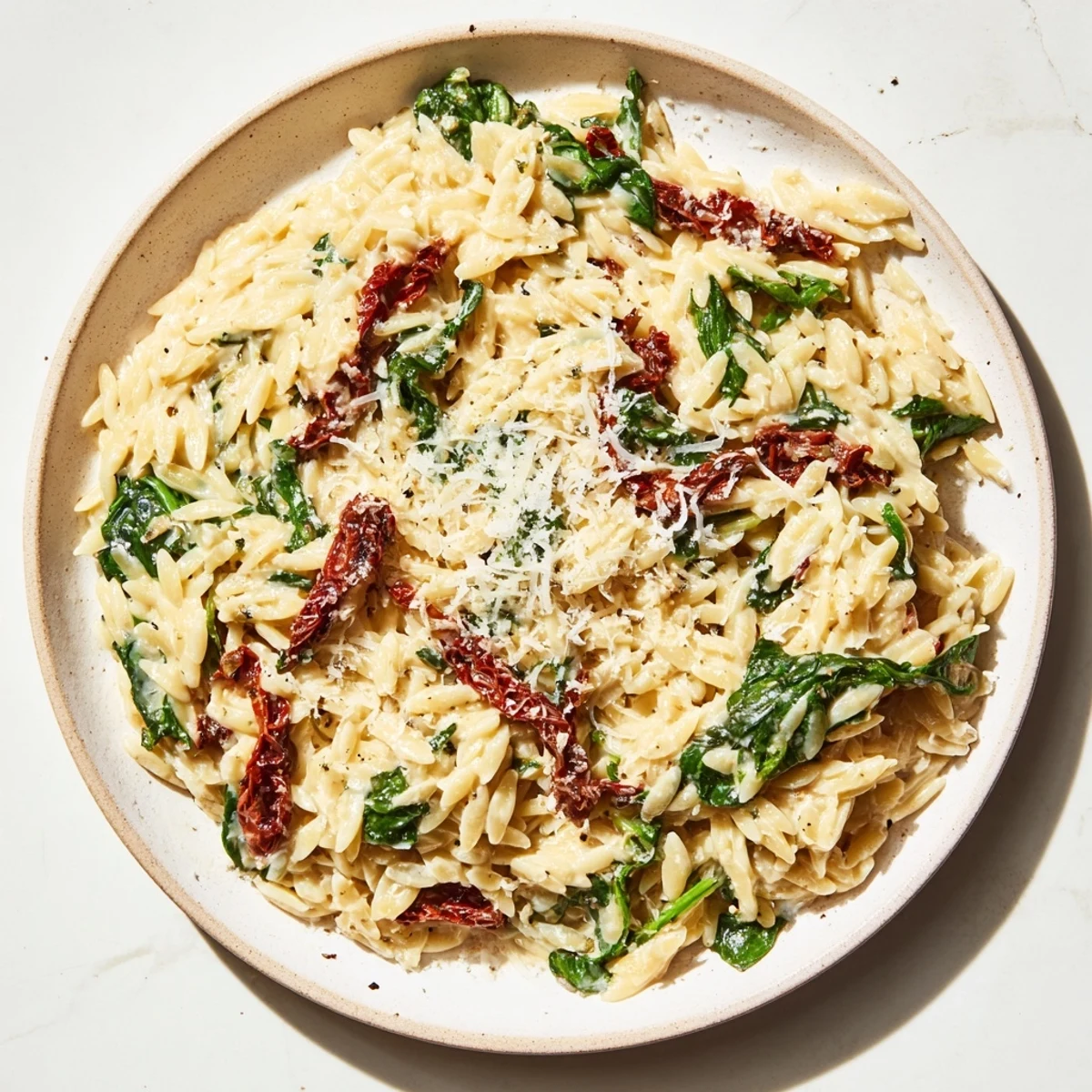 Creamy Tuscan Orzo Bowl with vibrant spinach, sun-dried tomatoes, and rich parmesan sauce, ready to serve.