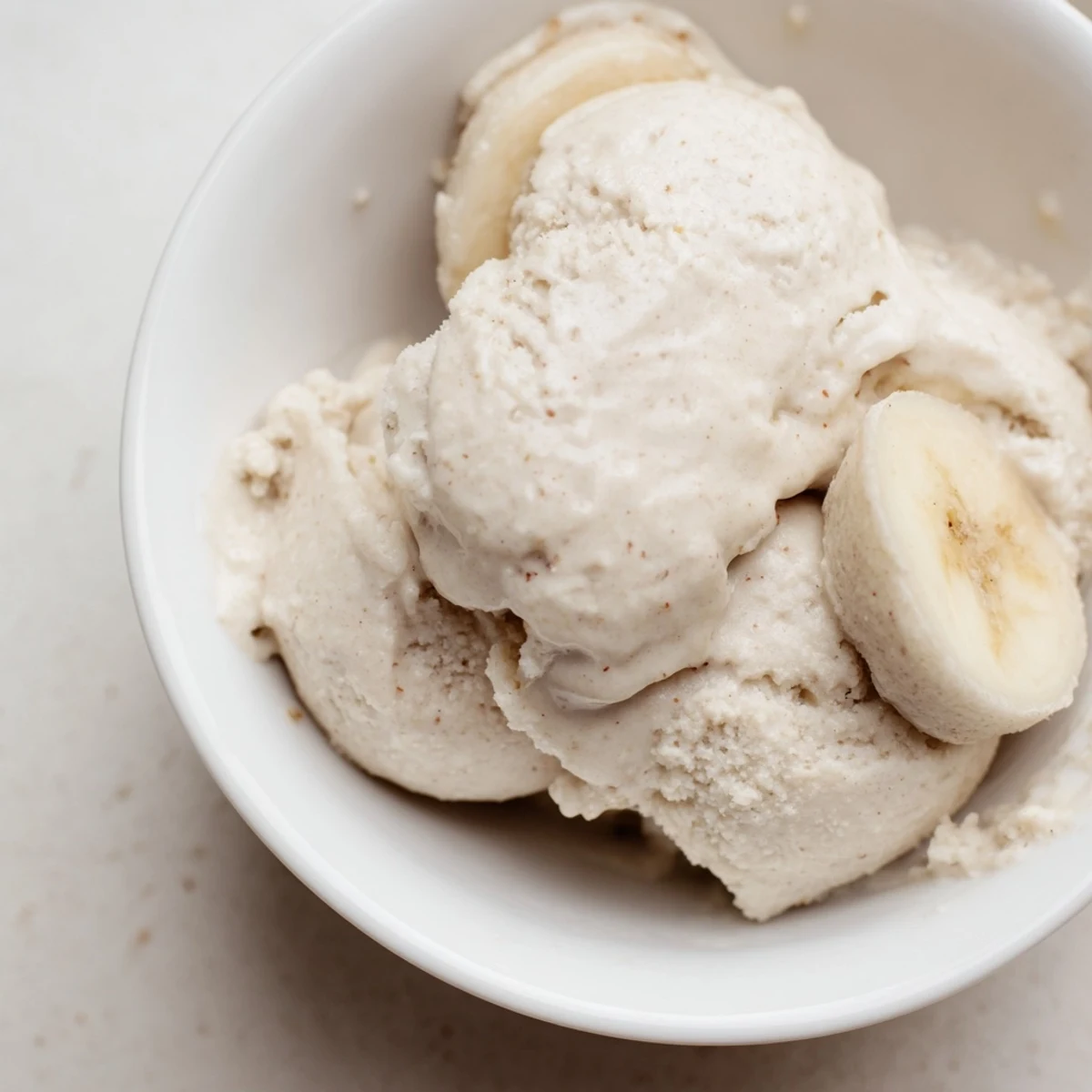 Creamy 2-Ingredient Banana Ice Cream swirls in a bowl, a healthy and delightful dessert.