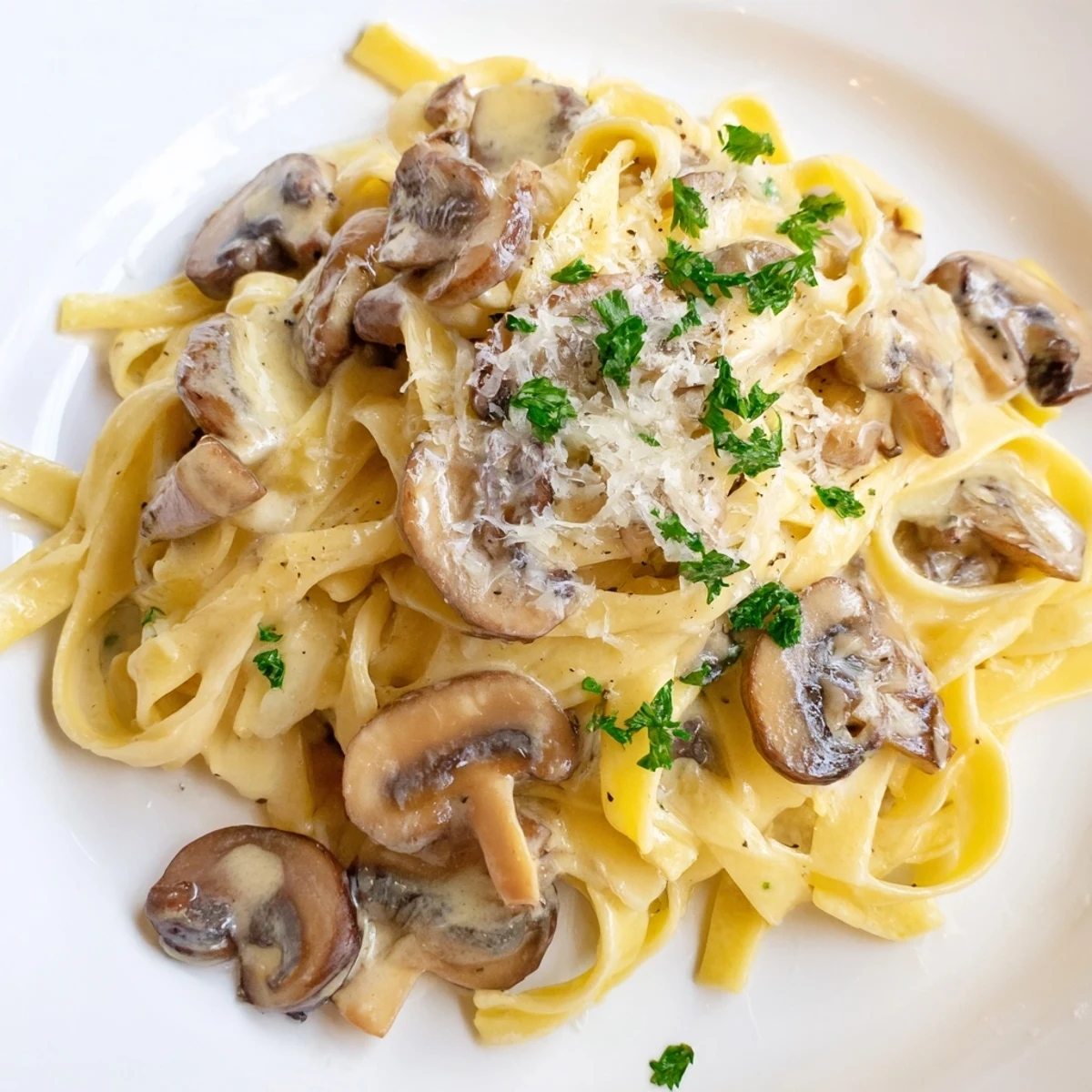 Hearty vegetarian Creamy Mushroom Alfredo garnished with extra Parmesan, ready to serve alongside crusty bread for dinner.