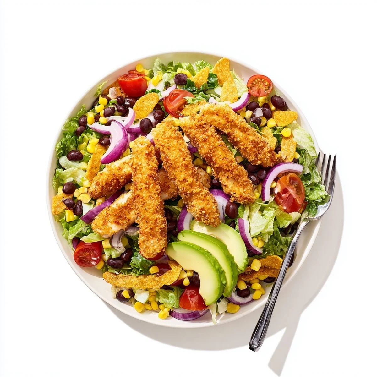 A freshly assembled Crispy Chicken Taco Salad with tortilla strips and creamy salsa ranch dressing.