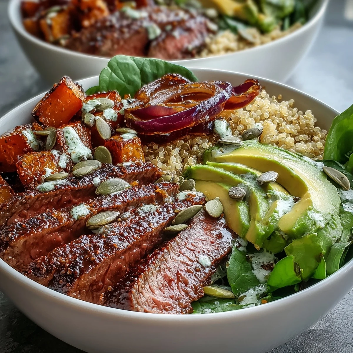 Golden-brown butternut squash steak bowls topped with creamy avocado and toasted pepitas on a bed of fluffy quinoa and greens.