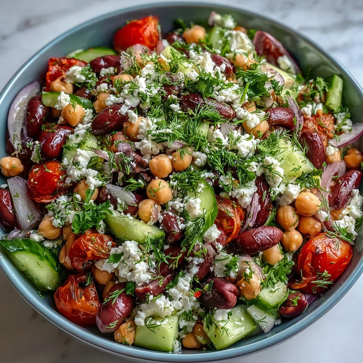 Creamy feta and briny Kalamata olives top a vibrant bowl of Greek Bean Salad with lemon-oregano dressing.
