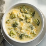 A close-up of a creamy Broccoli Cheese Soup, showcasing the tender broccoli florets and sharp cheese.