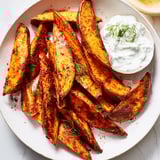 Crispy roasted sweet potato wedges, seasoned perfectly, ready to pair with fresh yogurt dip.