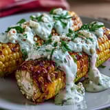 2. Creamy, tangy elote-style corn with Cotija cheese, smoky paprika, and lime, served hot and sprinkled with chili for a zesty kick.  