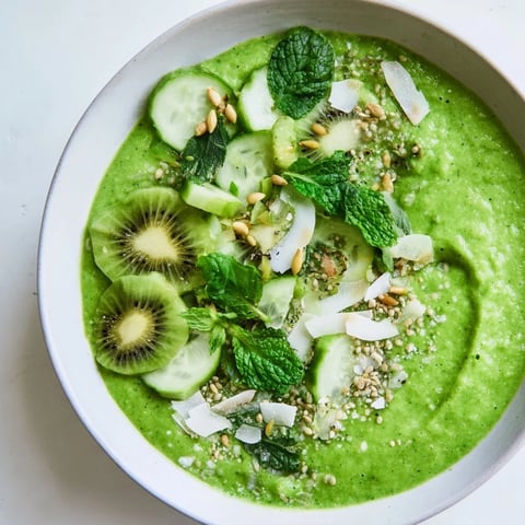 Creamy green smoothie bowl with kale, kiwi, and avocado, topped with fresh hemp seeds, ready to eat.