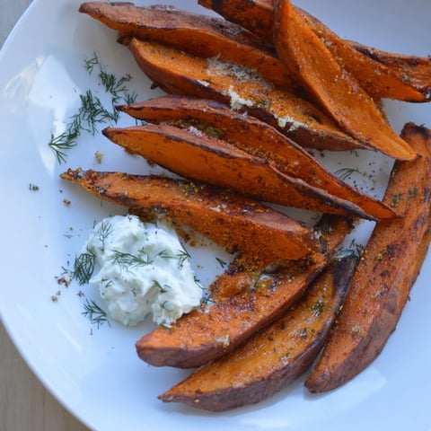 Golden brown roasted sweet potato wedges served with cool, creamy yogurt dip for dipping.