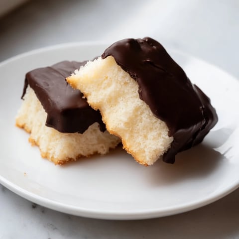 Golden-brown vanilla wafers dipped in glossy semi-sweet chocolate, a simple cookie delight.