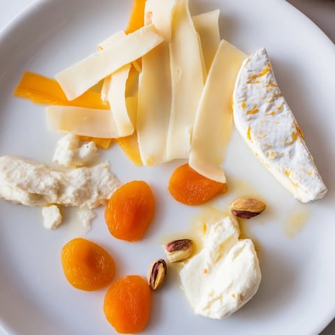 A beautifully arranged The Saffron Silk cheese board with yellow cheeses, perfect for elegant serving.