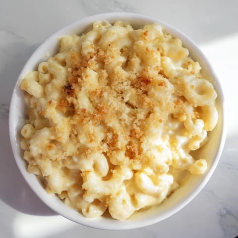 Golden, bubbly Tinis Recession Mac and Cheese, a budget-friendly comfort food delight.