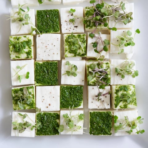 Beautiful The Checkerboard Garden appetizer, showcasing creamy white cheeses and flavorful green herbs.