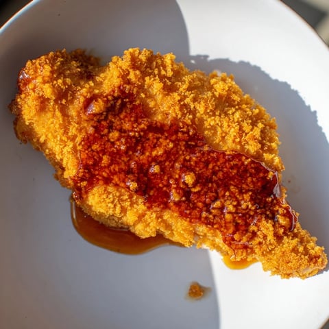 Crispy golden edges of the Hot Honey Crispy Chicken Thighs glistening with a sweet, spicy glaze.