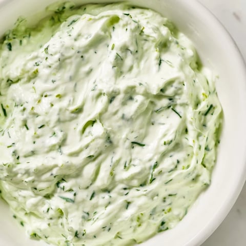 This Green Goddess Salad Dip is a creamy, herb-packed appetizer in a rustic bowl, surrounded by crisp tortilla chips and colorful vegetable sticks.