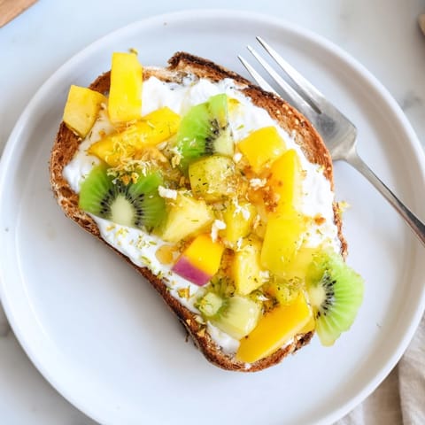 Deliciously vibrant Yogurt-Custard Toast with tropical fruits and a honey drizzle.  