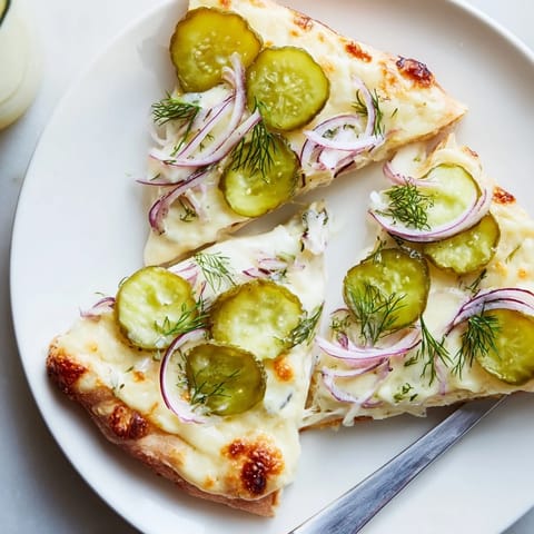 Delicious Pickle Pizza served hot, featuring rich crème fraîche and fresh dill.  