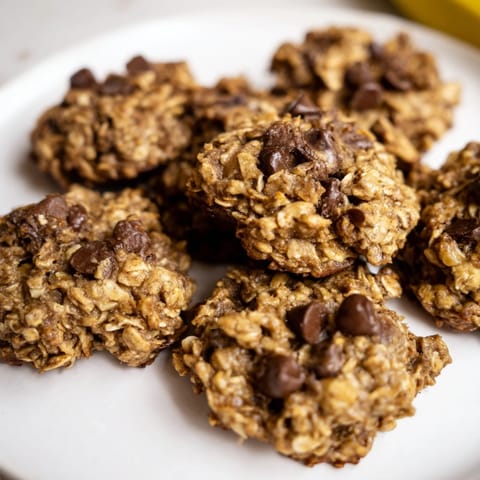 A stack of delicious Oat-Banana Chocolate Chip Cookies, fresh from the oven, offering a sweet aroma.