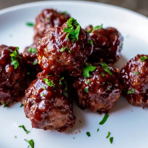 Mouthwatering image of cherry BBQ meatballs simmering, ready to serve over rice for a delicious dinner option.