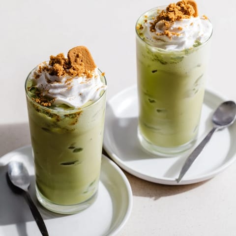 Frothy Sugar-Free Gingerbread Cookie Matcha Frappe with whipped cream and crushed cookies, a delicious treat.