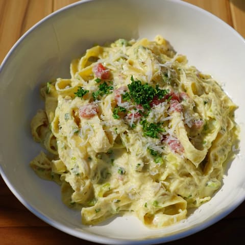 Garnished with parsley, the Skinny Alfredo Garlic Parmesan Snowy Pasta features a rich parmesan sauce, perfect for dinner.