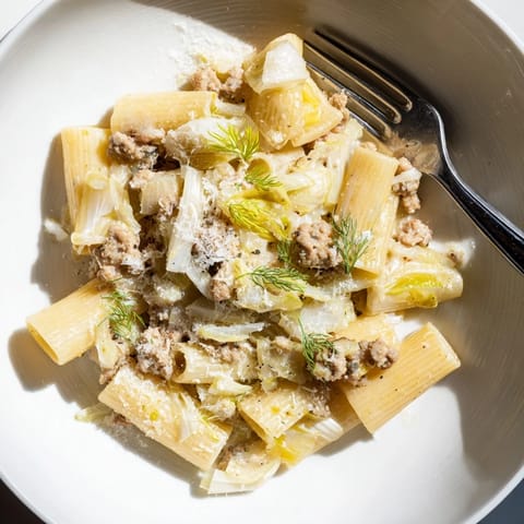 Fork twirling short pasta in Winter Pasta with Sausage and Fennel with garlic, onions, and spicy sausage.