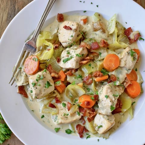 Freshly baked Chicken and Leek Pie with golden, flaky pastry bubbling over a deep pie dish.