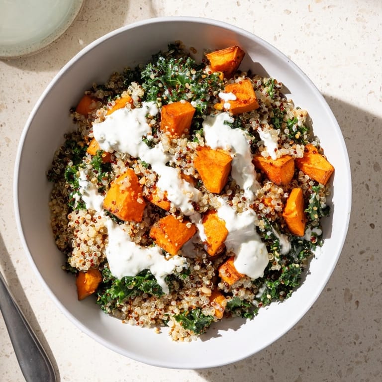 Savory roasted sweet potato quinoa bowl recipe with tender kale, ready for a healthy lunch.