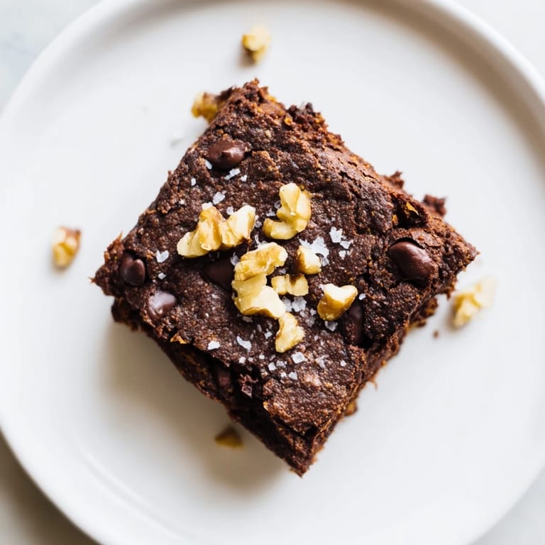 Warm, freshly-baked sweet potato brownies, featuring a moist texture and delicious chocolate flavor, ready to eat.