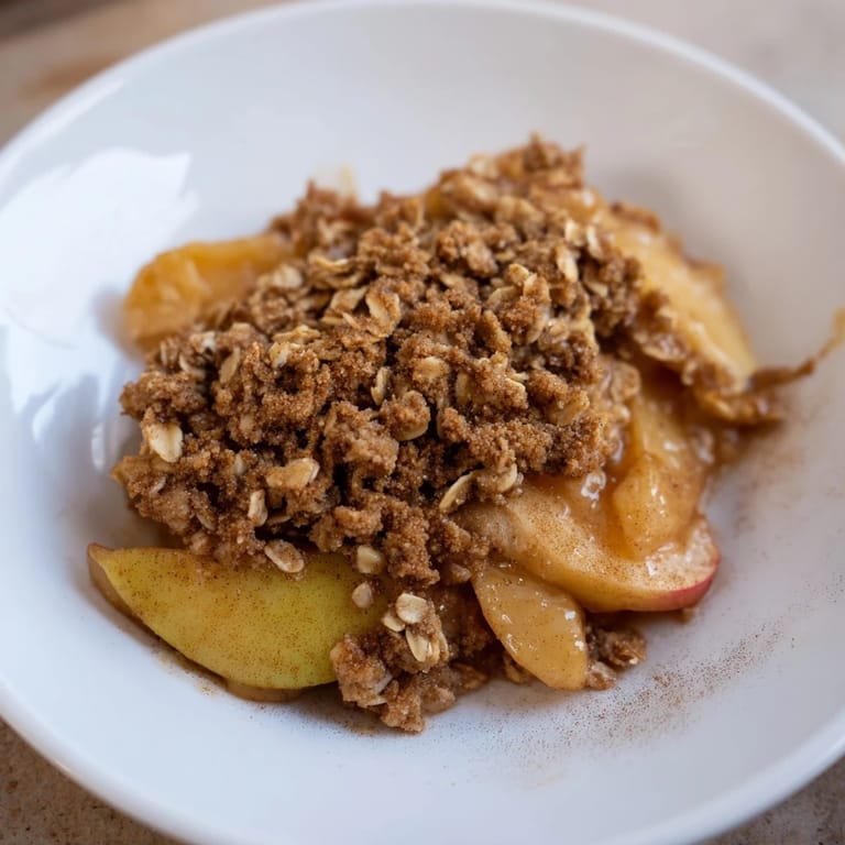 A close-up shot of freshly baked Apple Crisp, highlighting the golden, crisp topping and juicy apples.