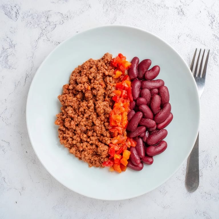 Appetizing close-up shows The Secret 4-Ingredient Chili with tender beef and vibrant tomatoes, ready to enjoy.